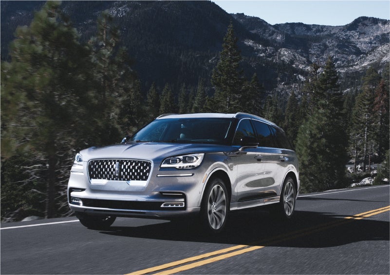 A 2023 Lincoln Aviator® Grand Touring SUV being driven on a winding road to demonstrate the capabilities of all-wheel drive | Lincoln of Cutler Bay in Miami FL