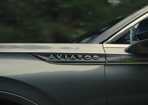 The driver’s side door and fender badging of a gray 2027 Lincoln Aviator® SUV are showcased. | Lincoln of Cutler Bay in Miami FL