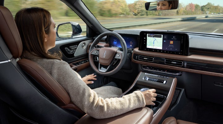 A 2027 Lincoln Aviator® SUV is being driven hands-free on a highway lined with trees. | Lincoln of Cutler Bay in Miami FL