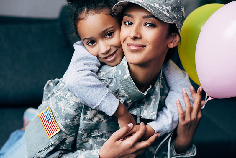 A retired military woman being hugged by her child