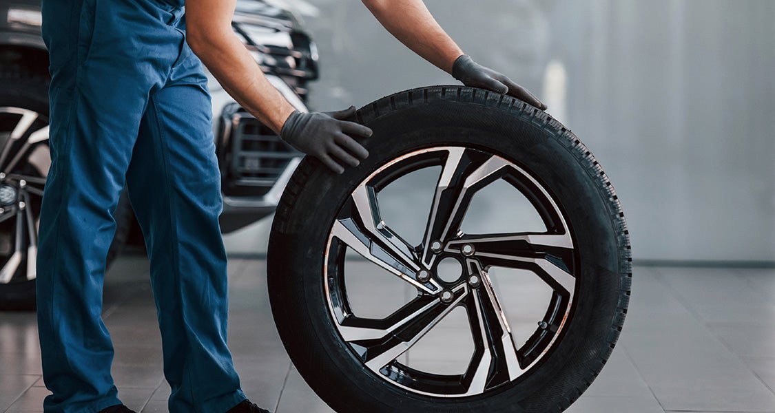 A wheel and tire being replaced on a vehicle
